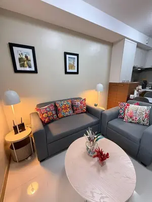 a living room with a couch and a table at European Vibe 1BR Great River City View Free Pool Gym Internet Netflix in Manila