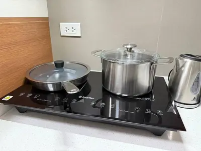 a stove with two pots and pans on top of it at European Vibe 1BR Great River City View Free Pool Gym Internet Netflix in Manila