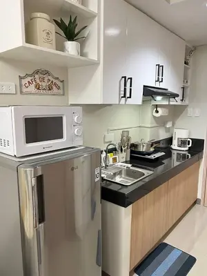 a small kitchen with a sink and a microwave at Paris Theme Near Ayala Feliz Mall 2BR Netflix Internet with Pool Parking Fee in Manila
