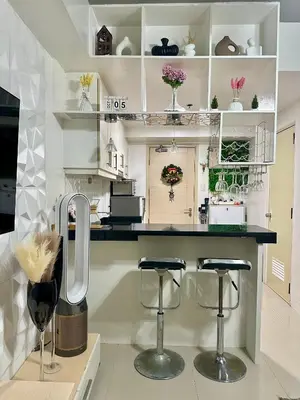 a kitchen with a counter with two bar stools at AMD Staycation in Manila