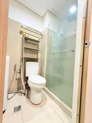 a bathroom with a toilet and a glass shower at Dreamstaycation shore residences in Manila