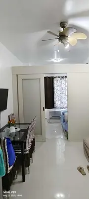 a dining room with a table and chairs and a ceiling fan at Sea Residences in Manila