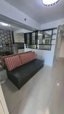 a black couch sitting in a living room with at Sea Residences in Manila