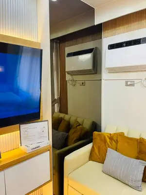 a living room with a couch and a flat screen tv at 19s CAI in Manila