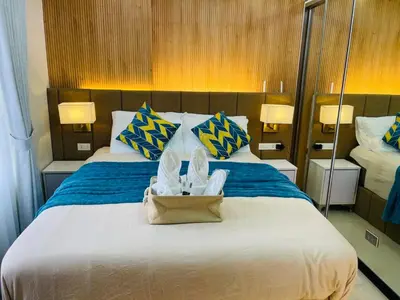 a bedroom with a large bed with blue and yellow pillows at 19s CAI in Manila