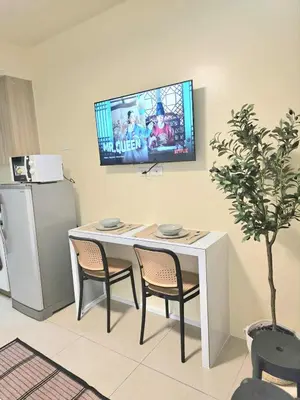 a table with two chairs and a television on a wall at Kaizen Pod - Shore Residences Staycation, MOA Complex, Near airport in Manila