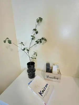 a plant in a vase on a table with a book at Kaizen Pod - Shore Residences Staycation, MOA Complex, Near airport in Manila