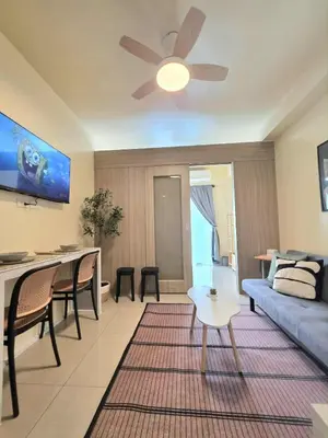 a living room with a couch and a ceiling fan at Kaizen Pod - Shore Residences Staycation, MOA Complex, Near airport in Manila