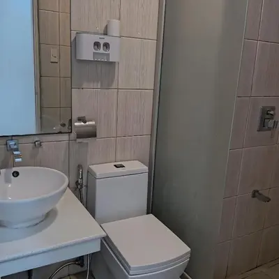 a bathroom with a white toilet and a sink at Birch Tower Ocean View Unit in Manila
