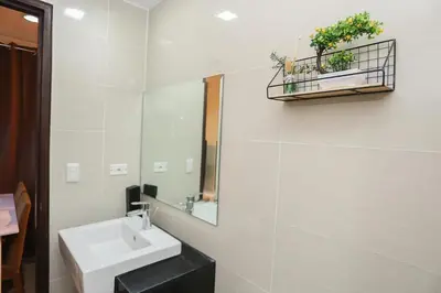 a white bathroom with a sink and a mirror at AdahkuMaya Luxury Suites in Manila