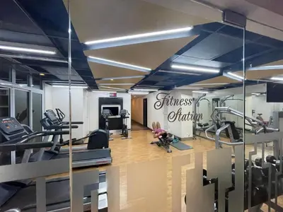 a gym with treadmills and exercise equipment and a mirror at AdahkuMaya Luxury Suites in Manila