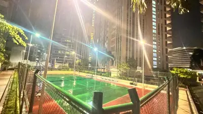 a green volleyball court in a city at night at AdahkuMaya Luxury Suites in Manila