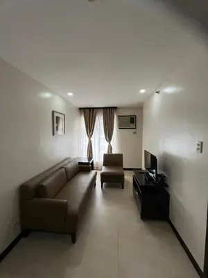 a living room with a couch and a television at A Venue Residences 80G in Manila