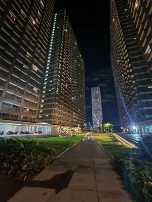 a city street at night with tall buildings at Entire unit 1 Bedroom with City View - Paul Riley's Pad in Manila