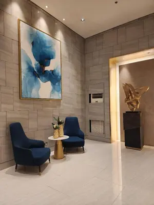 a lobby with two chairs and a table and a painting at Entire unit 1 Bedroom with City View - Paul Riley's Pad in Manila