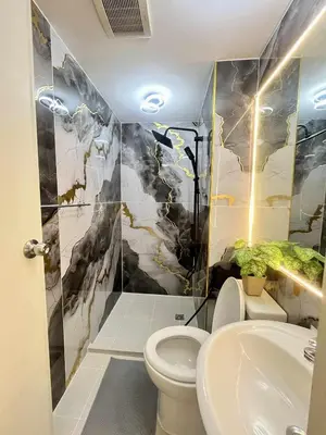 a bathroom with a toilet and a sink at Urban Retreat at Azure in Manila