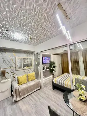 a bedroom with a bed and a couch and a table at Urban Retreat at Azure in Manila