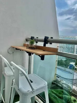 a table and chair on a balcony with a window at Urban Retreat at Azure in Manila