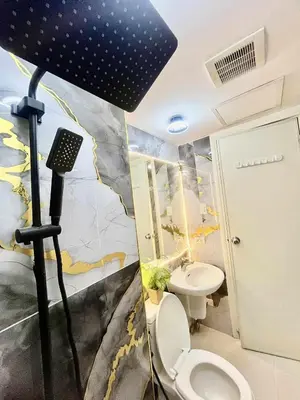 a bathroom with a toilet and a black umbrella at Urban Retreat at Azure in Manila