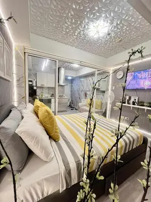 a bedroom with a large bed with yellow pillows at Urban Retreat at Azure in Manila