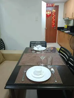 a table with a plate and a cup and aucer on it at Family Suites 4 Shell Condo MOA 653B in Manila