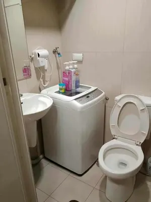 a small bathroom with a toilet and a sink at Family Suites 4 Shell Condo MOA 653B in Manila