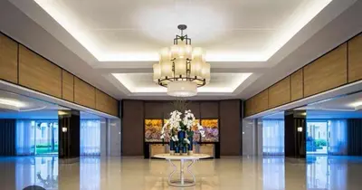 a lobby with a chandelier and a table with flowers at Family Suites 4 Shell Condo MOA 653B in Manila