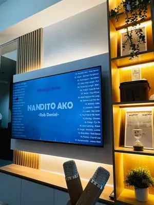 a tv screen on a wall with two remote controls at Suite 07 MOA GRAND STAY Newly Turn over Only in Manila