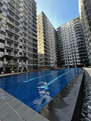 a swimming pool in front of two tall buildings at Suite 07 MOA GRAND STAY Newly Turn over Only in Manila