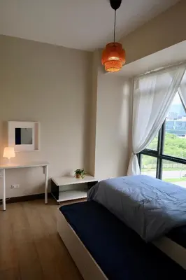 a bedroom with a bed and a desk and a window at Bright & Cozy Condo Near Okada 2 mins walk in Manila