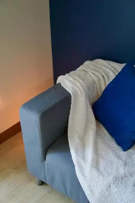 a blue couch with a blanket on top of it at Bright & Cozy Condo Near Okada 2 mins walk in Manila
