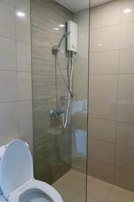 a shower stall in a bathroom with a toilet at Bright & Cozy Condo Near Okada 2 mins walk in Manila