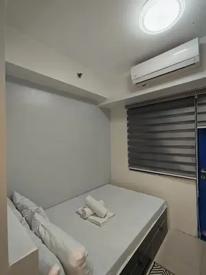 a white room with a bed with a fan at Sea residences MOA-MR in Manila