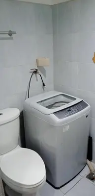 a white bathroom with a toilet and a sink at Sea residences MOA-MR in Manila