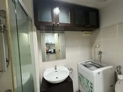 a bathroom with a sink and a toilet and a mirror at Sea Residences Vertex in Manila