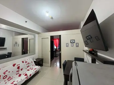 a bedroom with a bed and a desk with a computer at Sea Residences Vertex in Manila