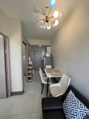 a living room with a dining room table and chairs at 2 bedroom modern unit in Manila