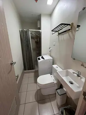 a bathroom with a white toilet and a sink at 2 bedroom modern unit in Manila