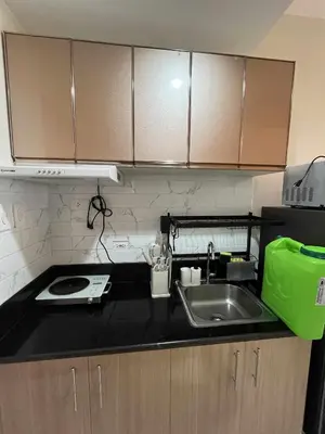 a kitchen counter with a sink and a microwave at 2 bedroom modern unit in Manila