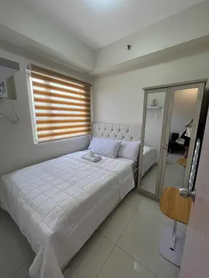 a bedroom with a large white bed and a window at 2 bedroom modern unit in Manila