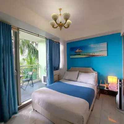 a bedroom with a bed and a large window at 320 Santorini Staycation in Manila