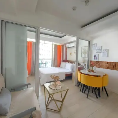 a hotel room with a bed and a yellow table at 320 Santorini Staycation in Manila
