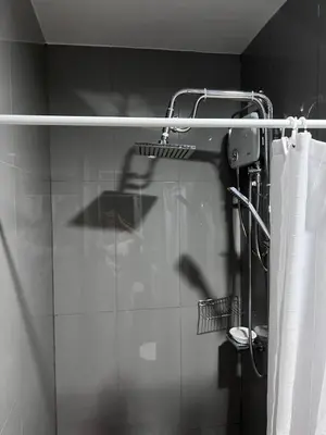 a shower in a bathroom with a shower curtain at Pleasant Air Residences City View in Sampong