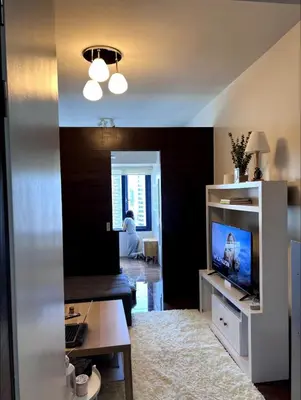 a living room with a flat screen tv and a couch at Pleasant Air Residences City View in Sampong