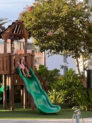 a child sitting on a slide at a playground at Pleasant Air Residences City View in Sampong