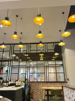 a restaurant with yellow lights hanging from the ceiling at Pleasant Air Residences City View in Sampong