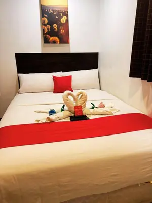 a bed with two dolls laying on it at City Stay Inns Slex Makati in Manila
