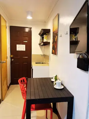 a black table and chairs in a room with a kitchen at City Stay Inns Slex Makati in Manila