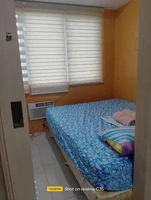 a bedroom with a bed in a room with windows at Kaoru Properties in Manila