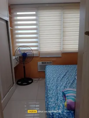 a bedroom with a bed and a fan in a room at Kaoru Properties in Manila